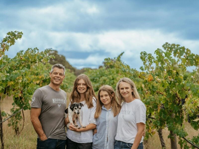 Dru, Nicole and their two girls in vineyards with dog Buster