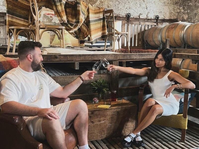 Couple enjoying wine tasting at Bellwethers Coonawarra, surrounded by vineyards and rustic charm.