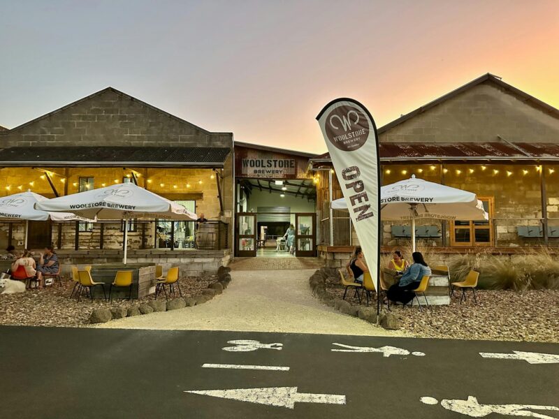 Exterior of brewery building, people seated at outdoor tables