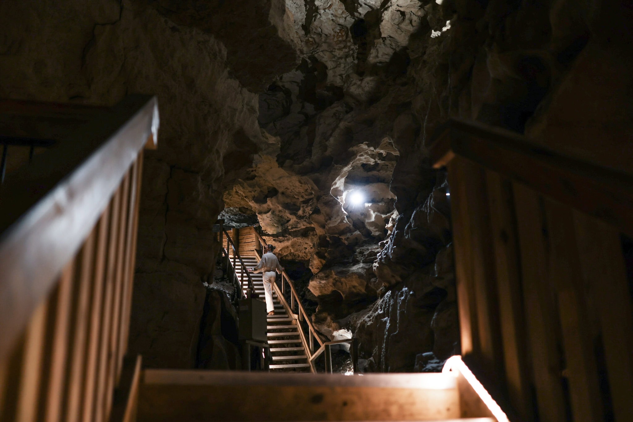 GIrl walking up staircase in dark cave