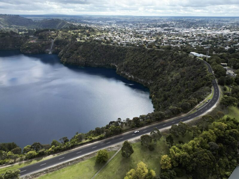 lake in a volcanic crater with city in the background