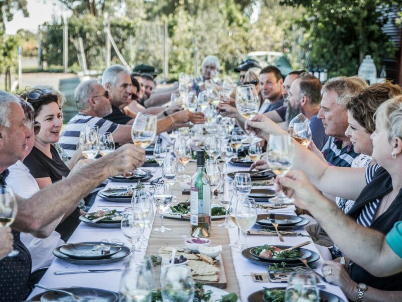 People enjoying food & wine at a long table lunch  part of Living the Dream wine making day