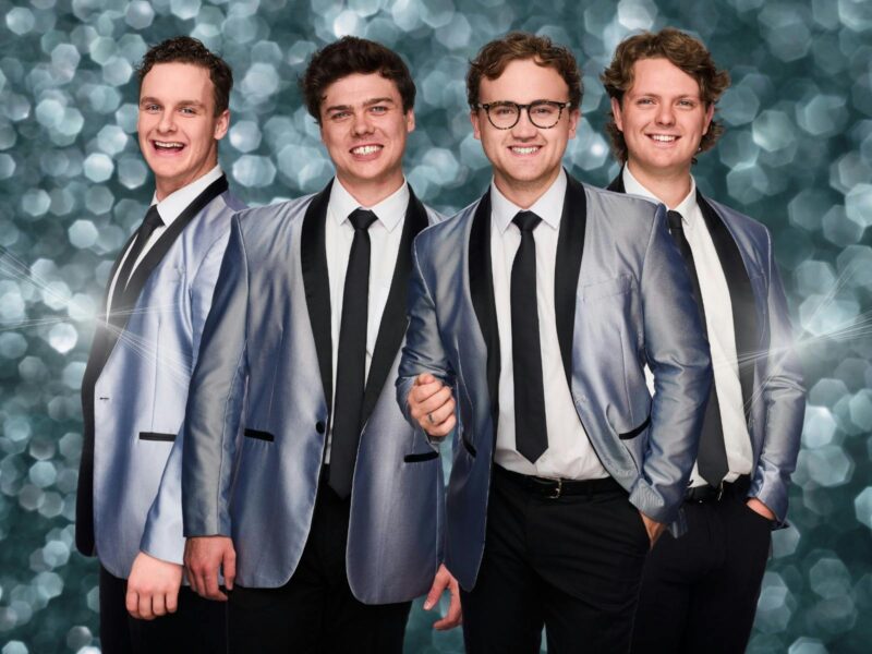 ATDW The 60 Four Hits Of The 60s And 70 Mount Gambier.jpeg Band members in silver jackets and ties, posing with smiles against a sparkling background.