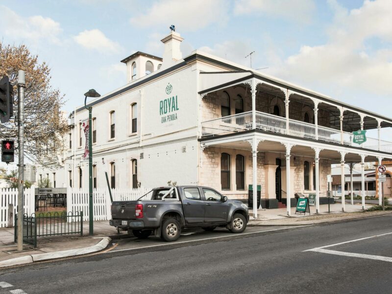 Street view of the Royal Oak Penola, a two-story building with a verandah and white picket fence.