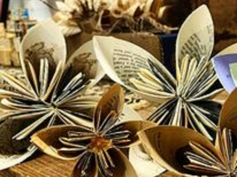 Artistic cleverly folded printed book paper like little umbrellas that look like flowers.