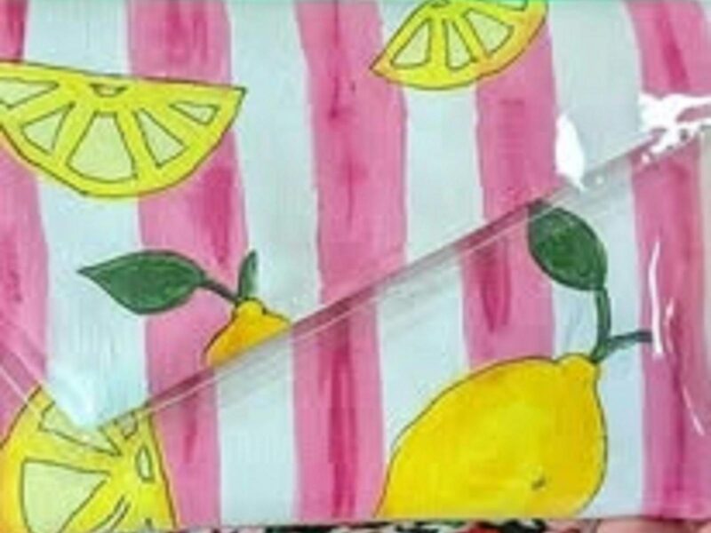 Pretty painted clutch purse decorated with pink stripes and yellow lemon slices .