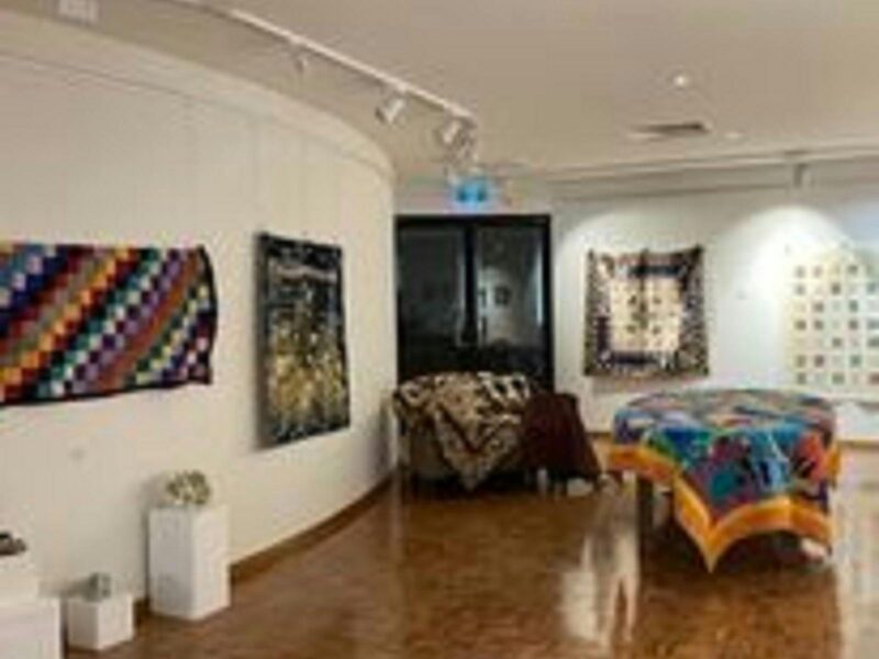 the interior of the Millicent Art Gallery.  It has a shiny wooden parquetry floor and white walls.