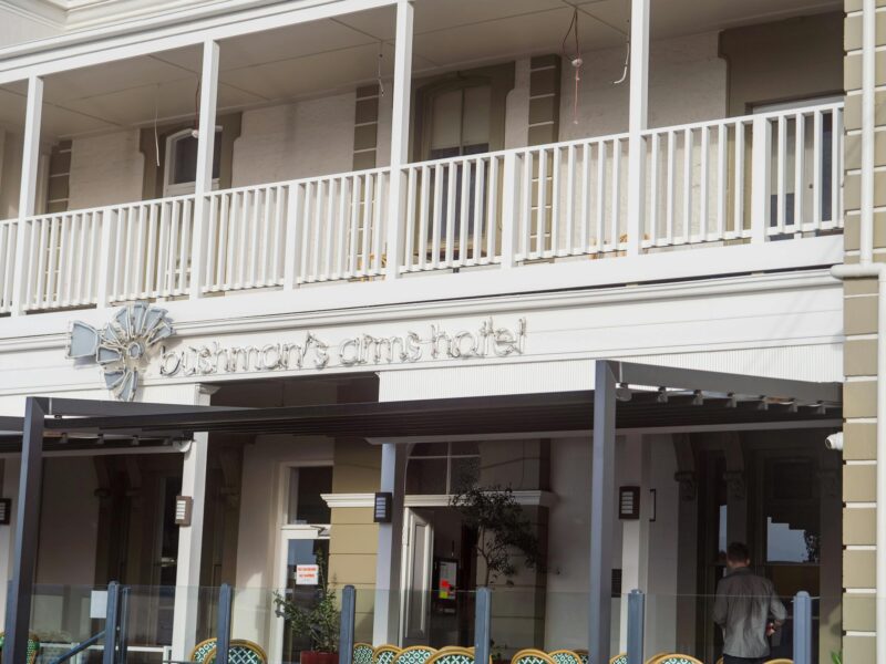 Front view of Bushman’s Arms Hotel featuring a white balcony and elegant architectural details.