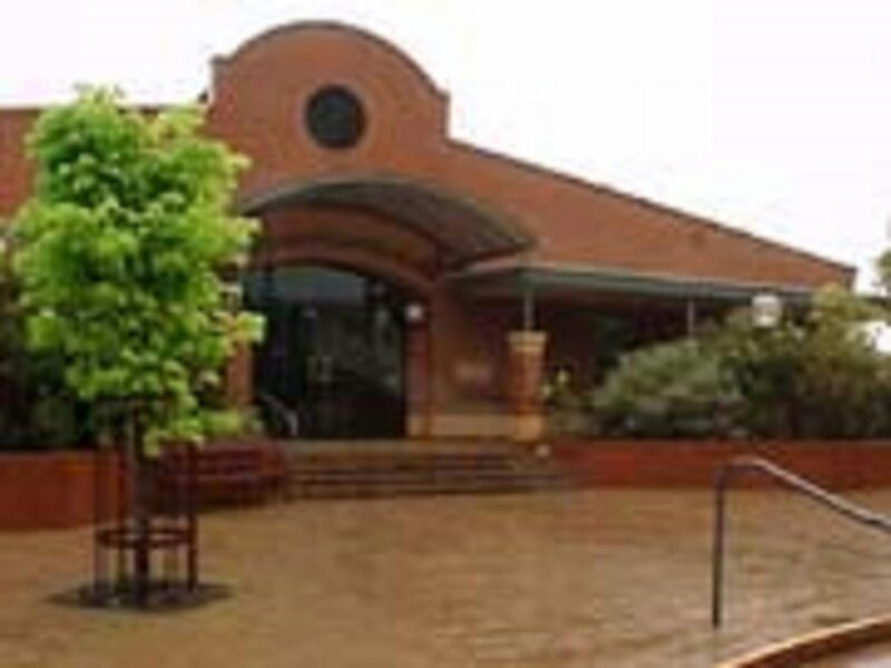 Millicent Library is a brick buildin with an arched entrance with stairs leading into the building.