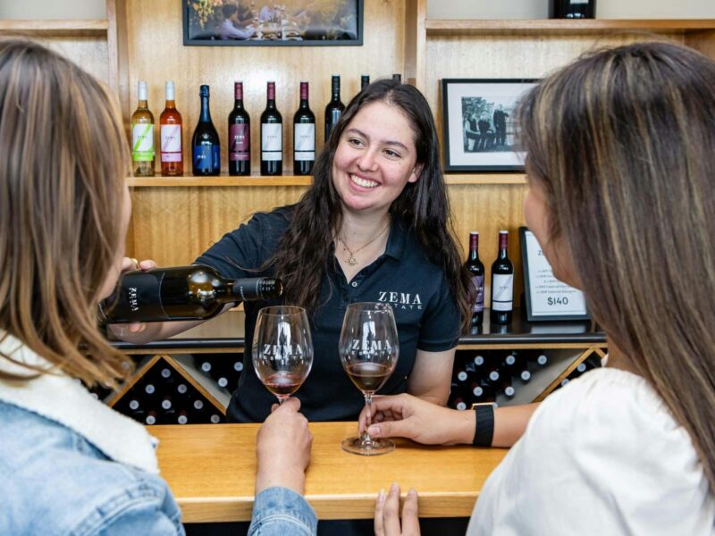 lady smiles and serves wine at zema estate coonawarra