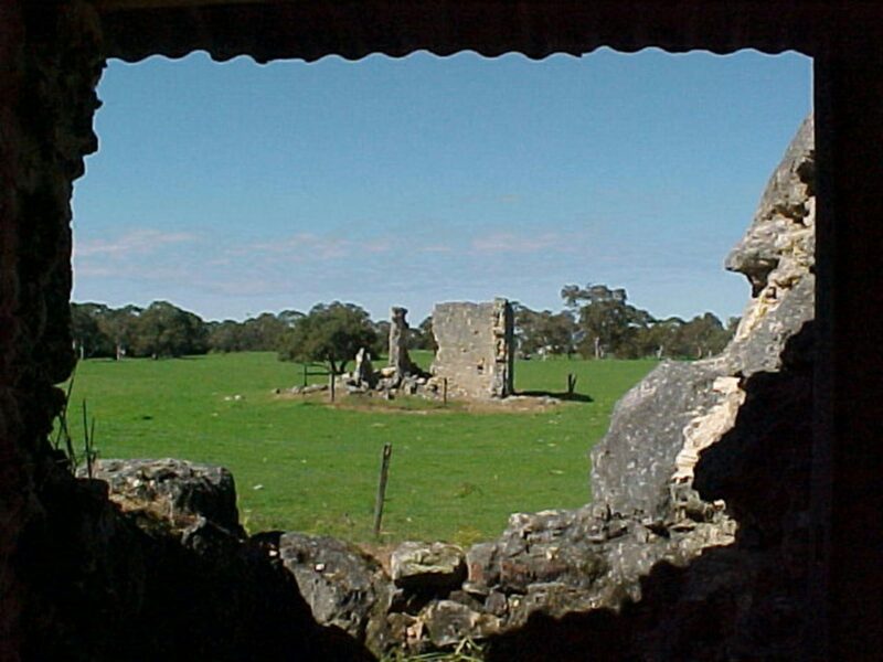 An artistic photo taken through a hole in the Kangaroo Inn ruins looking out to another ruin.