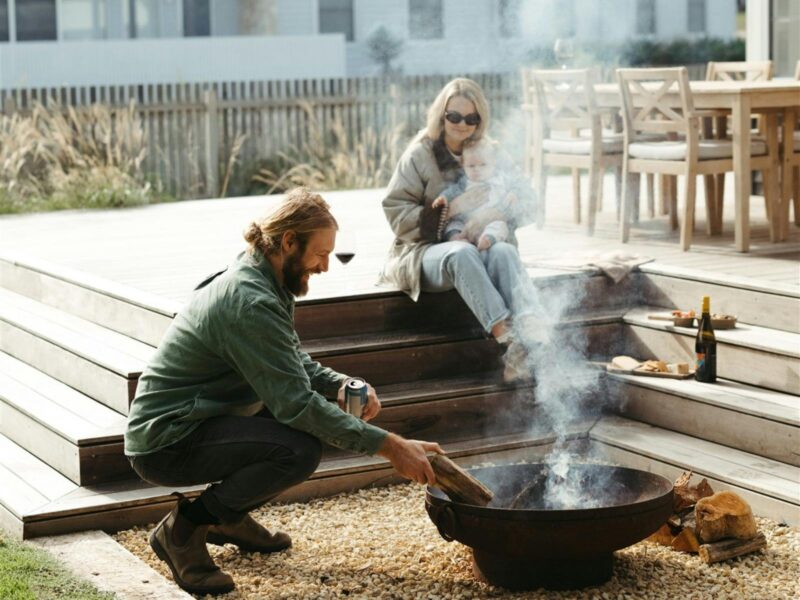 Couple sitting by outdoor fire pit with wine at Tea Tree Retreat accommodation in Robe South Austral