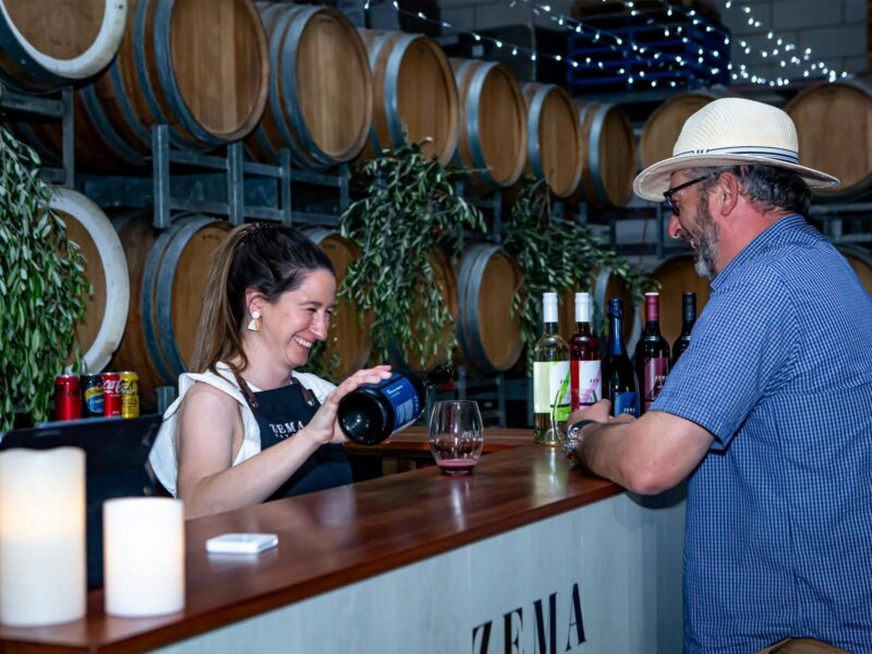 lady serves wine at Zema Estate pizza event